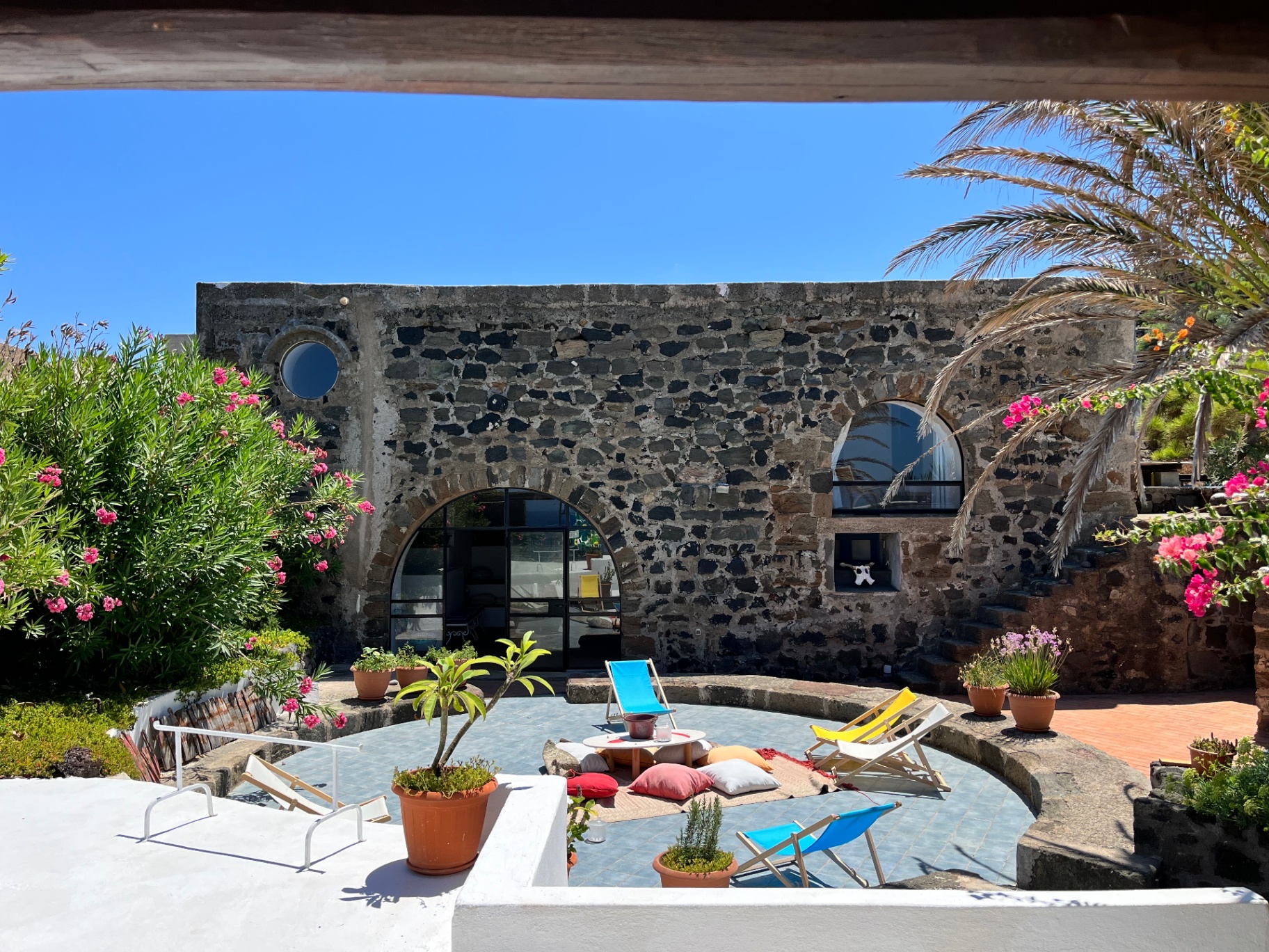 Stone facade of the Warehouse with arched glass door and sunken patio