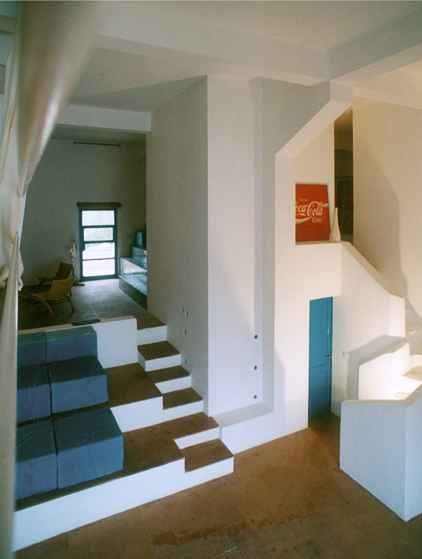 First level grand space of the Warehouse with staircase, blue cushions, and Coca-Cola artwork