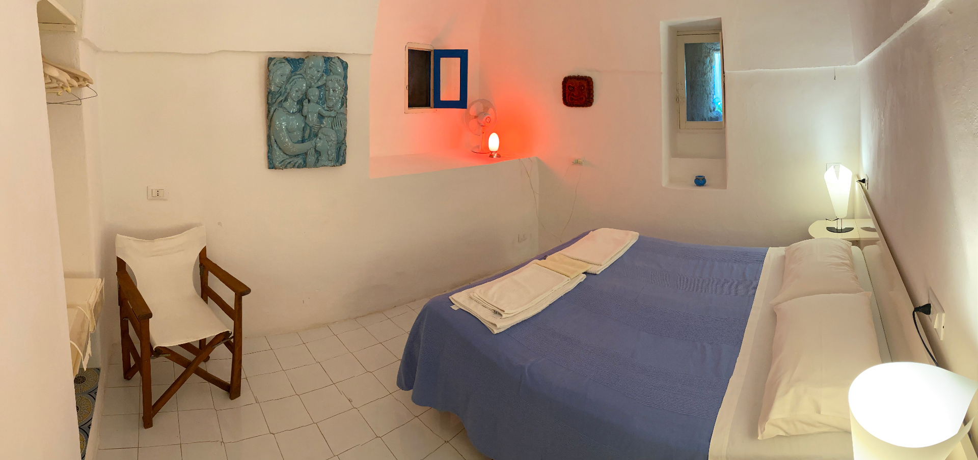 Camera Oscura bedroom with blue bedspread, ceramic relief and arched ceiling