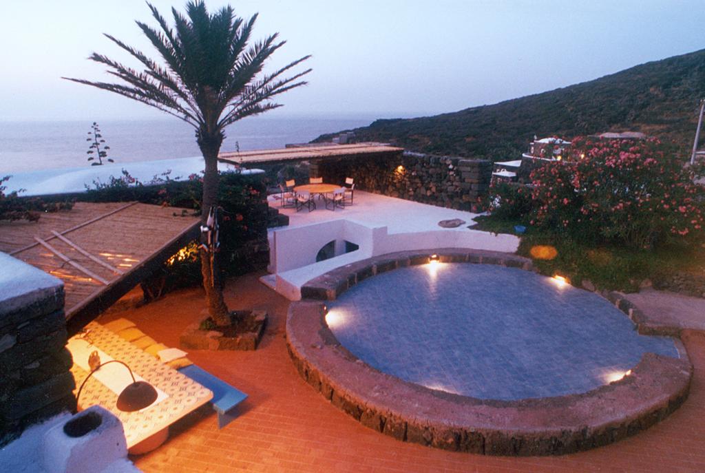 Central piazza at sunset with palm, plunge pool and sea view