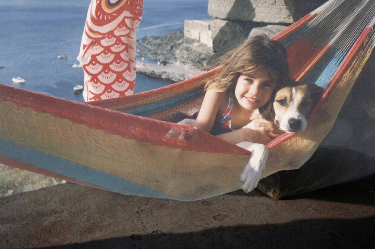 Young girl and her dog resting in a hammock above the bay at La casa dell'Elefante